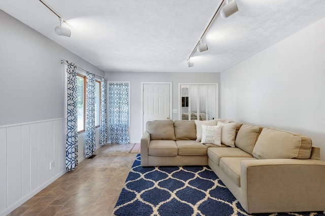 living room featuring track lighting and a textured ceiling