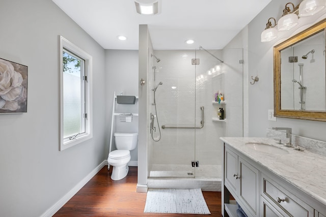 bathroom featuring toilet, plenty of natural light, hardwood / wood-style flooring, and vanity