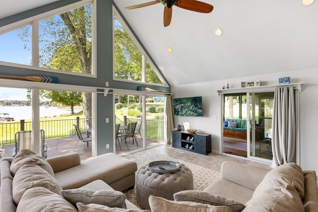 living room featuring ceiling fan, high vaulted ceiling, and a water view