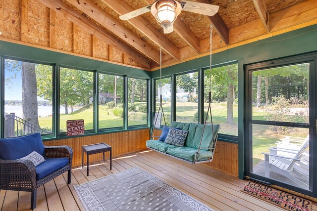 sunroom with a healthy amount of sunlight, ceiling fan, and vaulted ceiling with beams