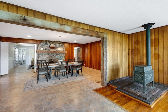 dining area featuring wood walls and a wood stove