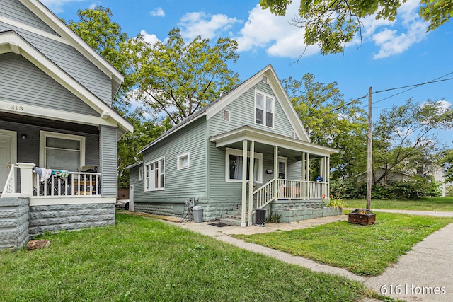 view of front of home featuring a porch, a front lawn, and a fire pit