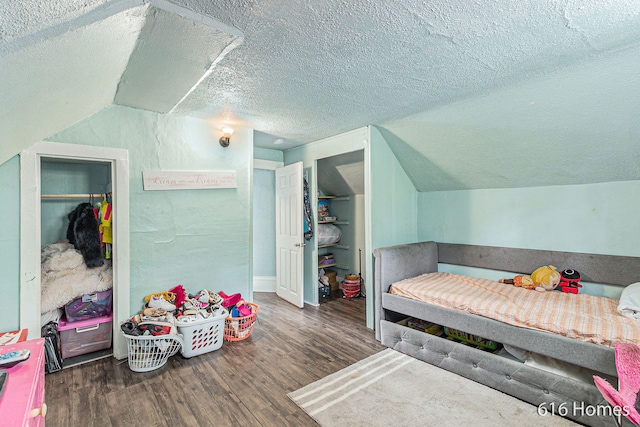 bedroom with dark hardwood / wood-style flooring, a textured ceiling, and vaulted ceiling