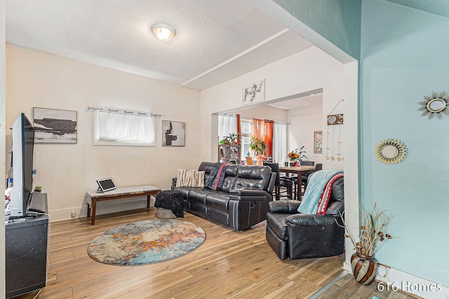 living room with light hardwood / wood-style floors and a textured ceiling