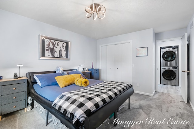 carpeted bedroom with a closet and stacked washer and dryer