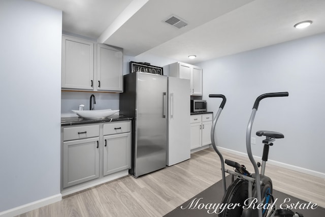 exercise area featuring light hardwood / wood-style floors and sink