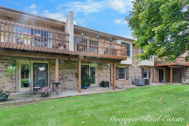 back of house featuring a yard, central AC, a patio area, and a balcony