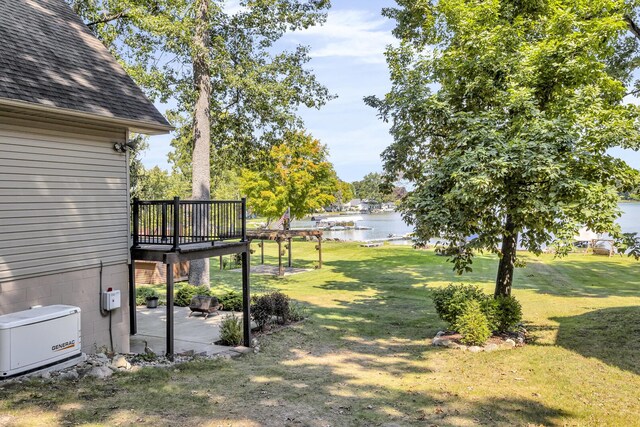 view of yard featuring a deck with water view and a patio