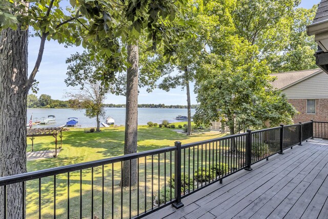 wooden terrace with a lawn and a water view