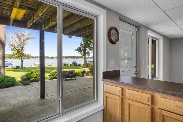 bar featuring a paneled ceiling and a water view