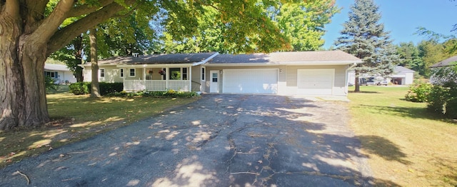 ranch-style house with a front lawn, a garage, and covered porch