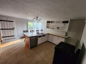 kitchen with appliances with stainless steel finishes, a textured ceiling, kitchen peninsula, and white cabinets