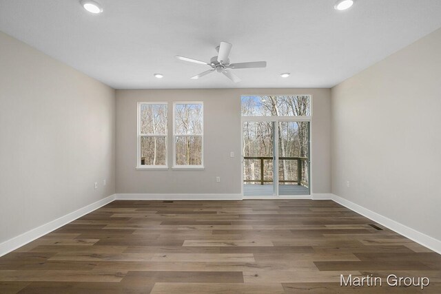 empty room with ceiling fan and dark hardwood / wood-style floors