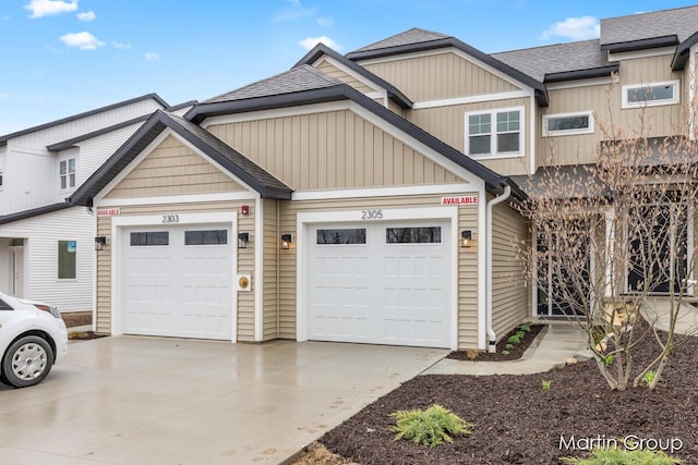 view of front of home with driveway, a shingled roof, board and batten siding, and an attached garage