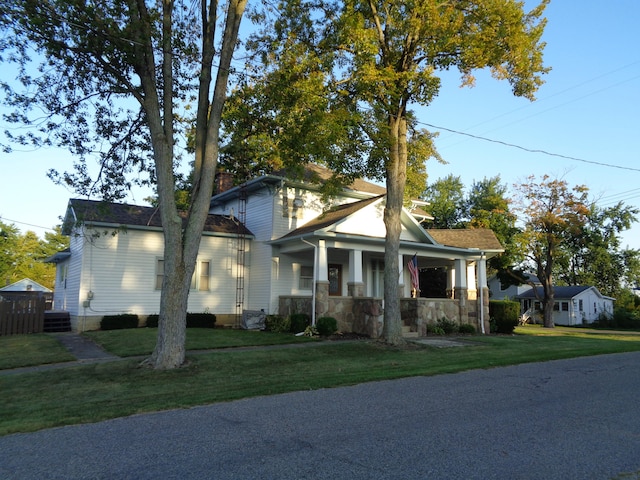 view of front of property featuring covered porch, central AC unit, and a front lawn