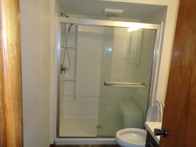 bathroom featuring vanity, toilet, and walk in shower