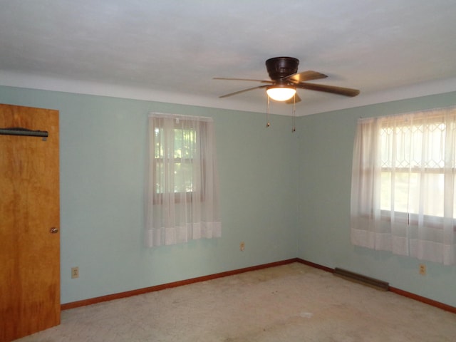 spare room featuring ceiling fan and light carpet