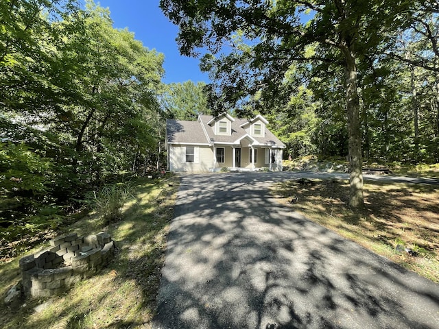 new england style home featuring aphalt driveway