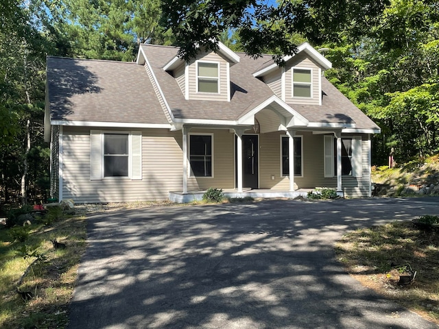 new england style home featuring covered porch