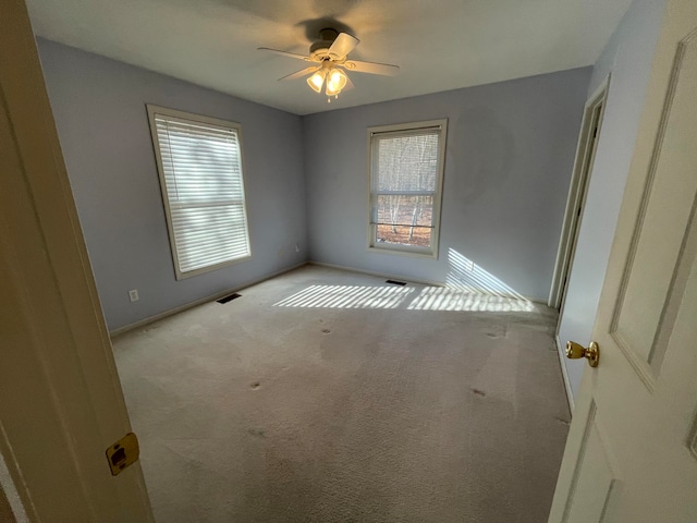 empty room featuring light colored carpet and ceiling fan