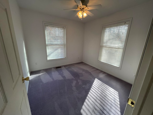 carpeted spare room featuring ceiling fan