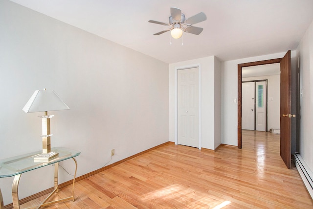 unfurnished bedroom featuring a baseboard radiator, ceiling fan, a closet, and light hardwood / wood-style floors