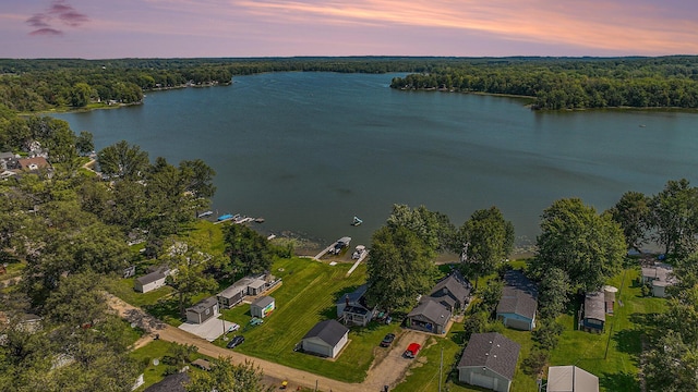 birds eye view of property with a water view and a wooded view