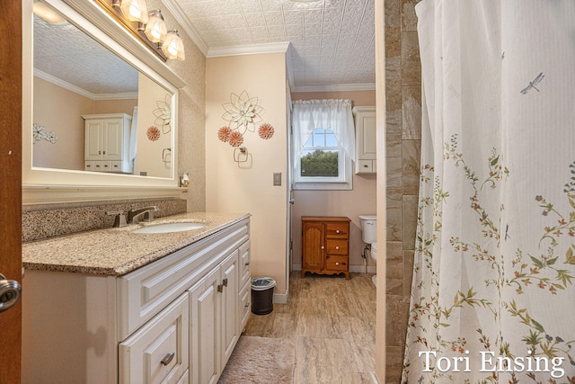 bathroom featuring a shower with shower curtain, vanity, toilet, and ornamental molding