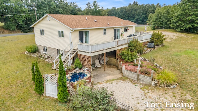 rear view of property with central air condition unit, a lawn, a deck, and a patio area