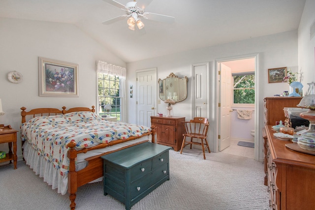 carpeted bedroom featuring ceiling fan, lofted ceiling, and ensuite bath