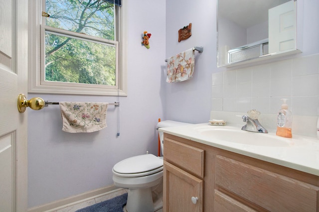 bathroom featuring tasteful backsplash, a shower with door, vanity, and toilet