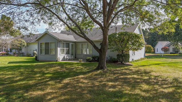 back of property featuring a lawn