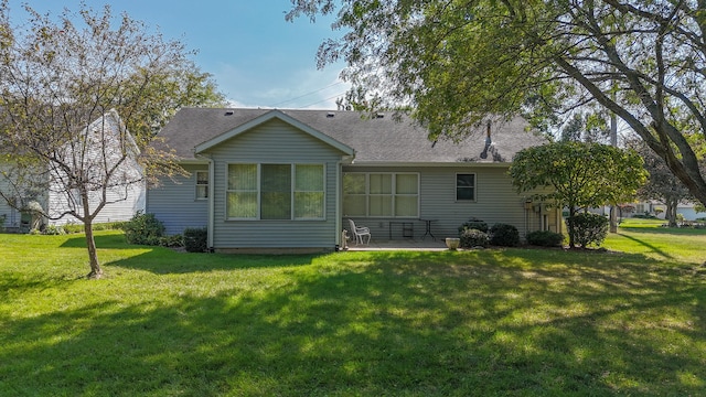 rear view of house with a yard and a patio