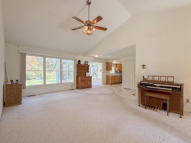 unfurnished living room featuring light carpet, high vaulted ceiling, and ceiling fan