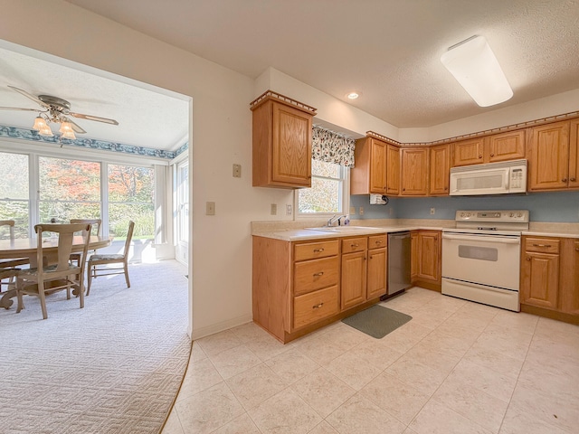 kitchen with ceiling fan, sink, light colored carpet, a textured ceiling, and white appliances