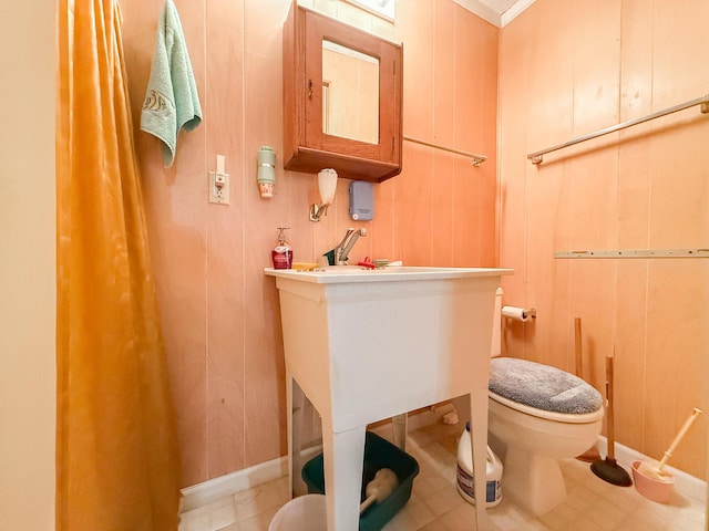 bathroom featuring toilet and wooden walls