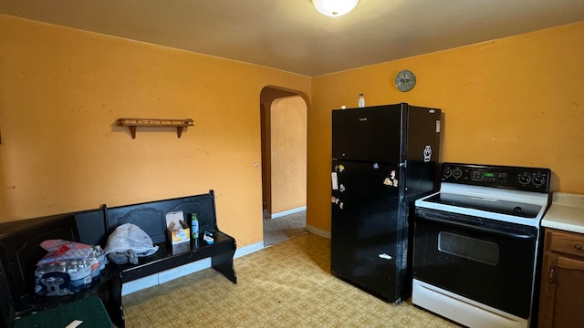 kitchen with white range with electric cooktop and black fridge