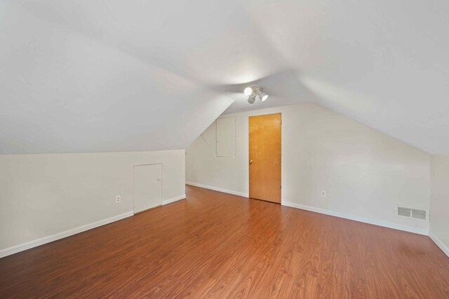 additional living space with lofted ceiling and hardwood / wood-style floors