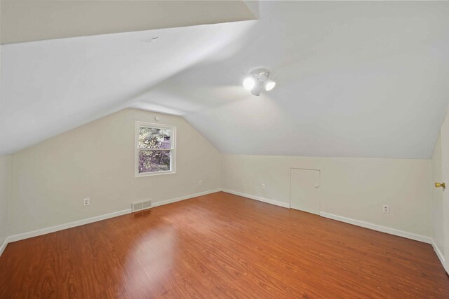 additional living space featuring lofted ceiling and hardwood / wood-style flooring