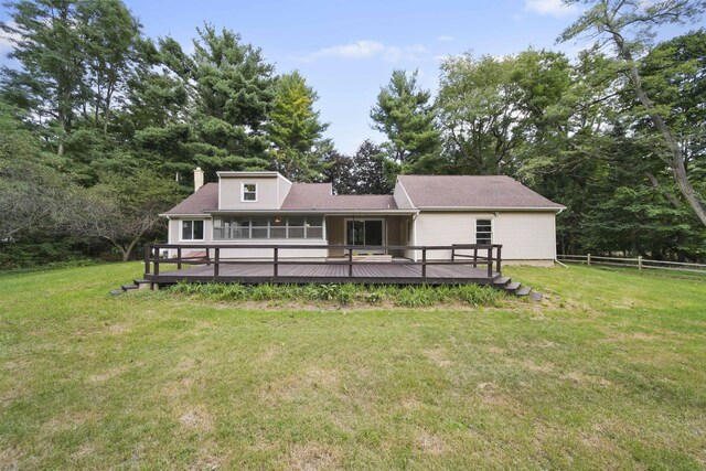 back of house featuring a wooden deck and a lawn