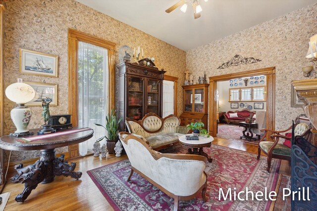 living area featuring hardwood / wood-style floors and ceiling fan