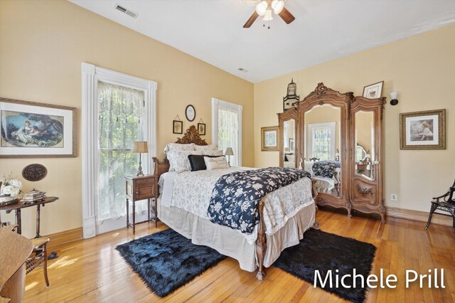 bedroom with light wood-type flooring, multiple windows, and ceiling fan