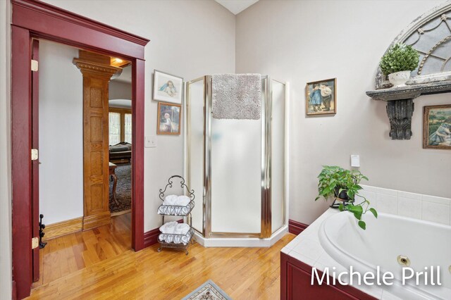 bathroom with separate shower and tub, wood-type flooring, and ornate columns