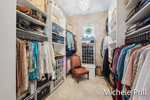 spacious closet with an inviting chandelier and light carpet