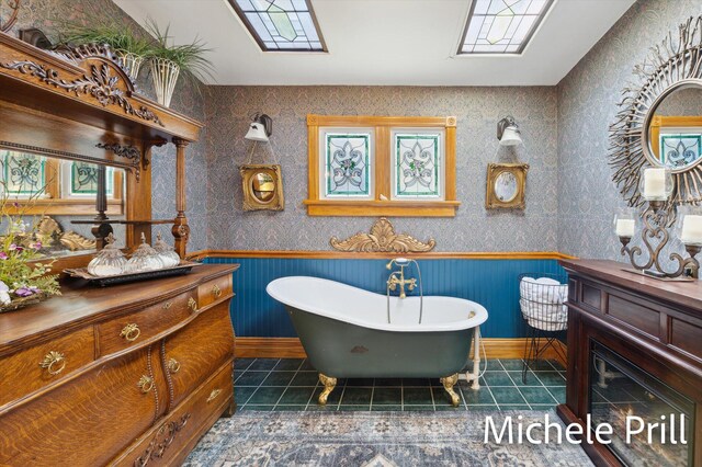 bathroom with a tub to relax in, vanity, and tile patterned flooring