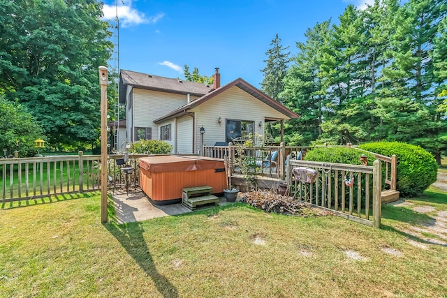 back of house featuring a wooden deck, a lawn, and a hot tub