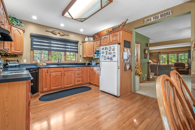 kitchen featuring white fridge, light hardwood / wood-style floors, a textured ceiling, and sink