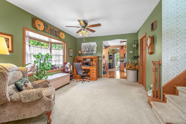 carpeted living room with ceiling fan and a textured ceiling