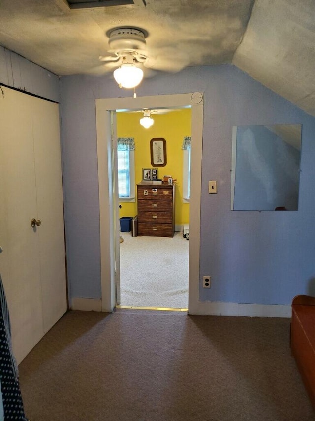 interior space with lofted ceiling, carpet floors, and a textured ceiling