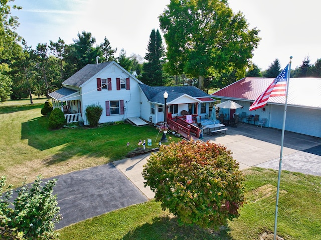 view of front of home featuring a garage, covered porch, and a front lawn